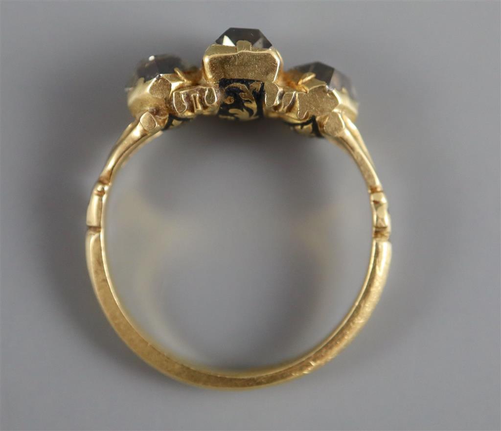A Georgian 18ct gold, three stone diamond and black enamel ring,